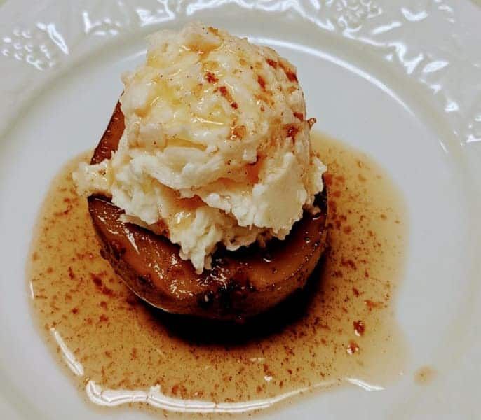 A white plate topped with a scoop of ice cream