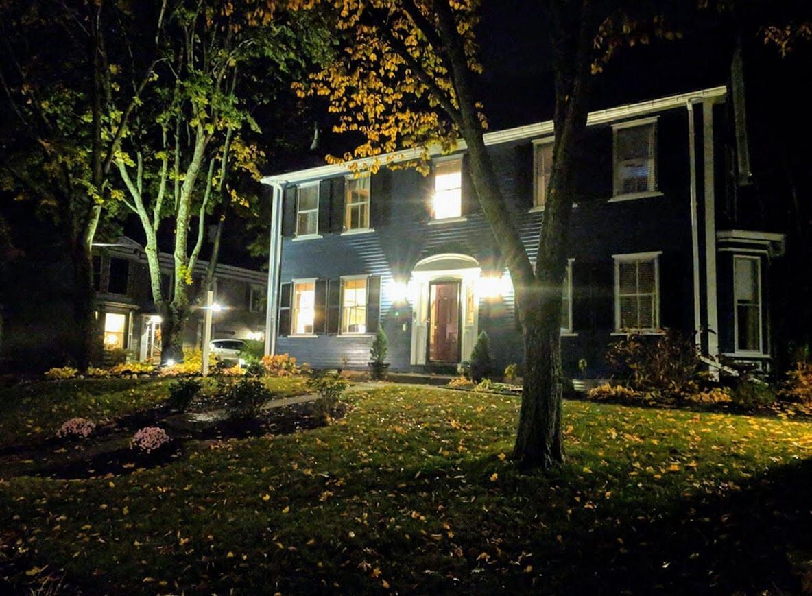 A large blue house is lit up at night