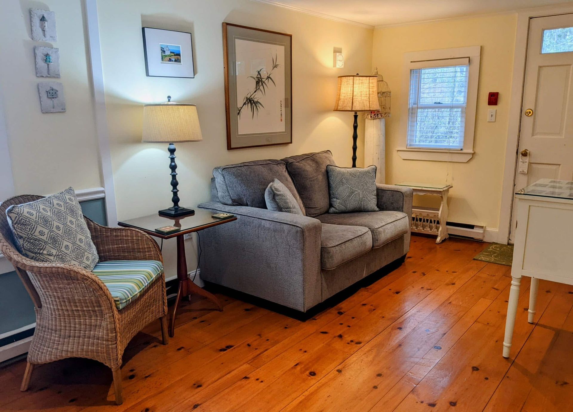 A living room with a couch , chair , table and lamp