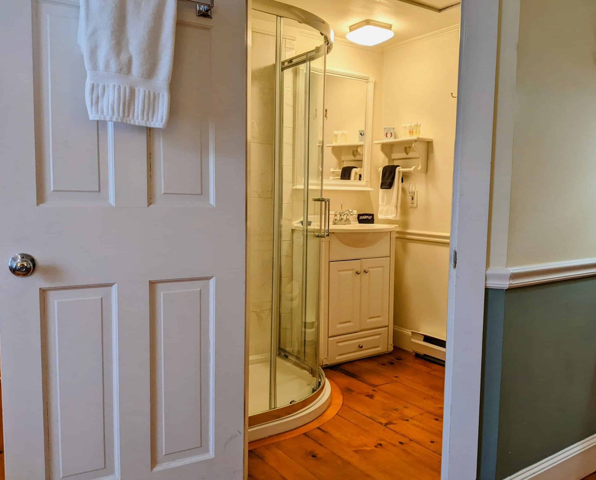 A bathroom with a walk in shower and a sink