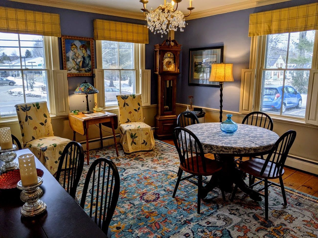 A living room with a table and chairs and a clock.