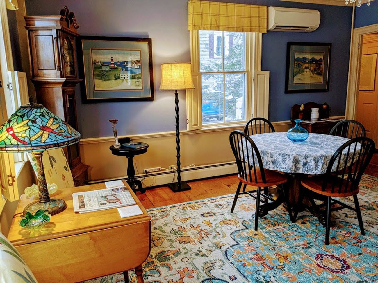 A living room with a table and chairs and a lamp