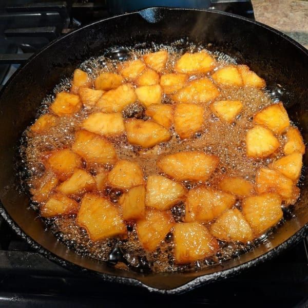 Potatoes are being cooked in a skillet on a stove.