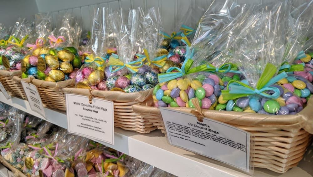 A shelf filled with baskets filled with colorful candy.