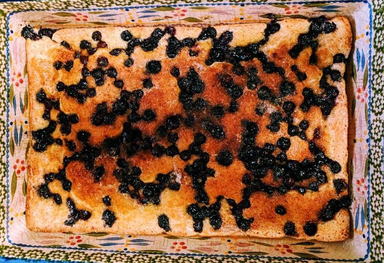 A piece of cake with blueberries on top of it