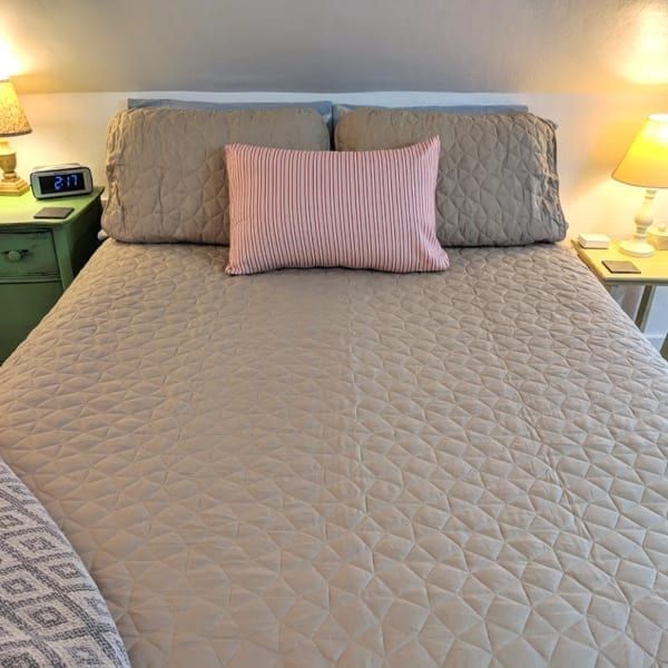 A bed with a pink pillow on top of it