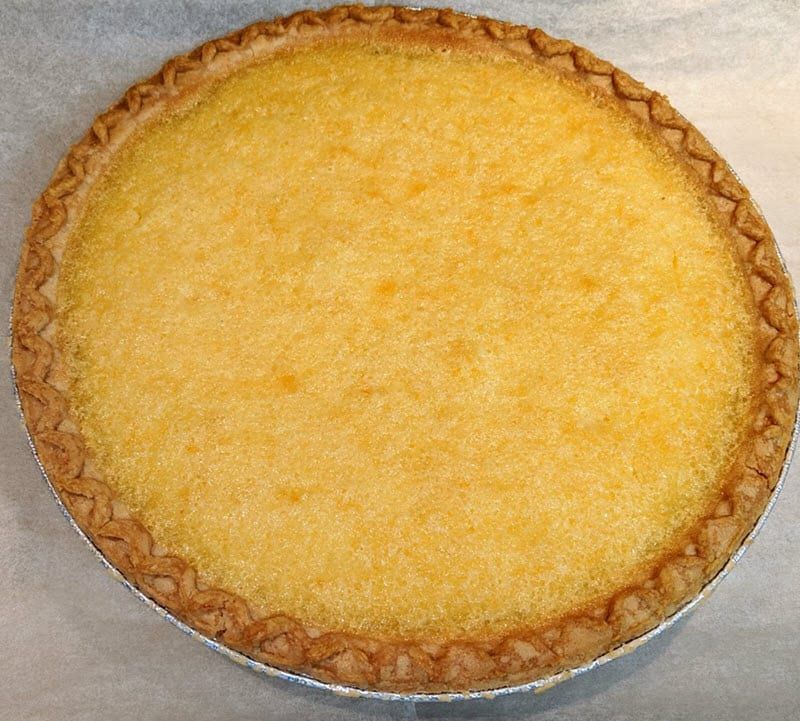 A yellow pie with a brown crust sits on a table