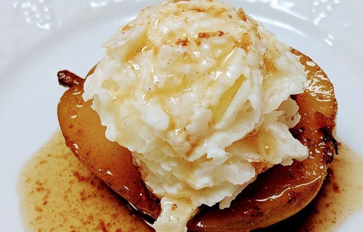 A close up of a plate of food with whipped cream on top.