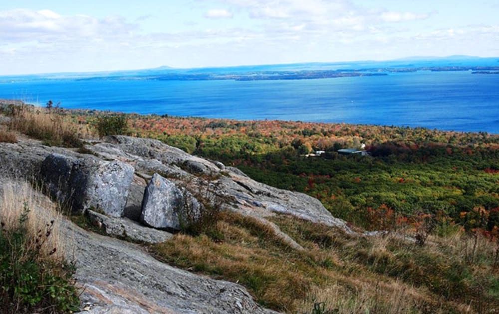 A view of a large body of water from a rocky hillside.