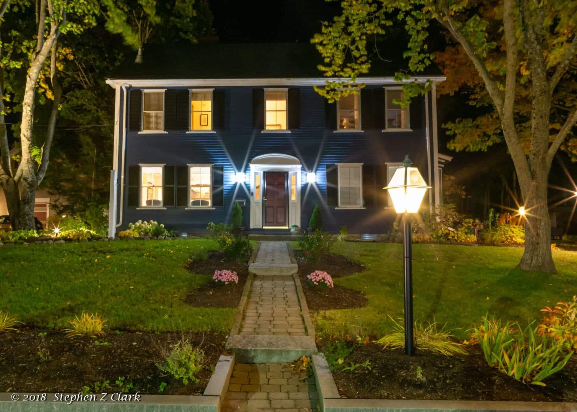 A large blue house is lit up at night