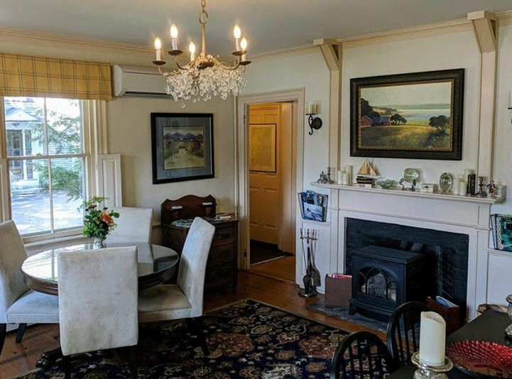 A living room with a fireplace and a table and chairs