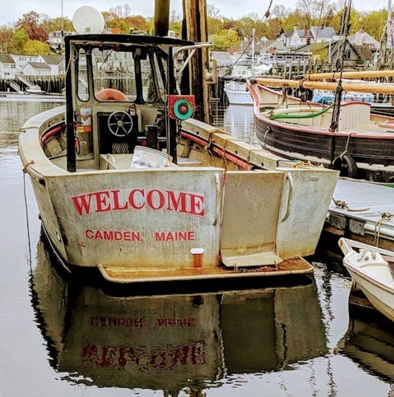 A boat that says welcome is docked in the water