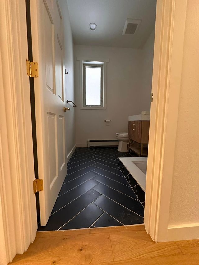 Room with hardwood floors and floor-to-ceiling forest views