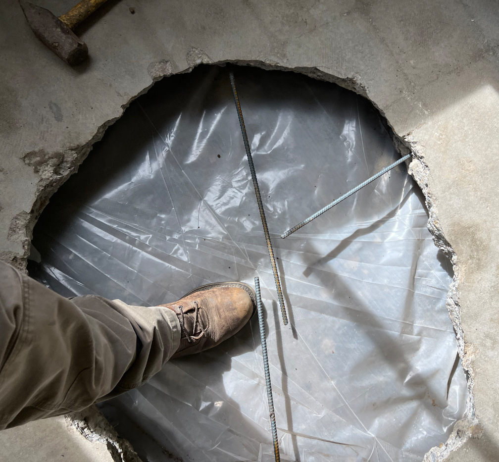 A Person Is Standing Above A Hole In The Floor - Oxnard, CA - 4J's Plumbing And Drain Cleaning
