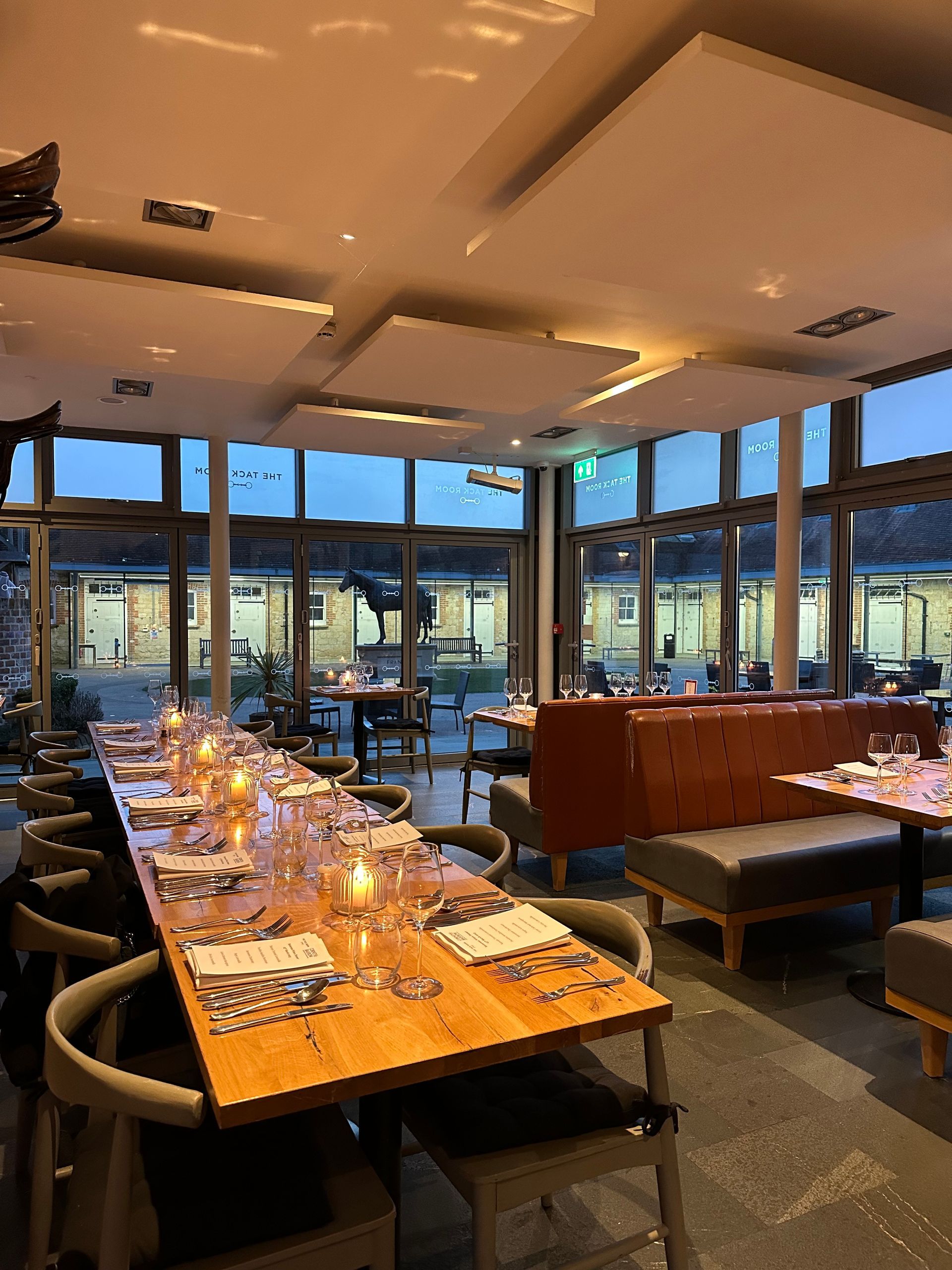 A restaurant with a long wooden table and chairs.