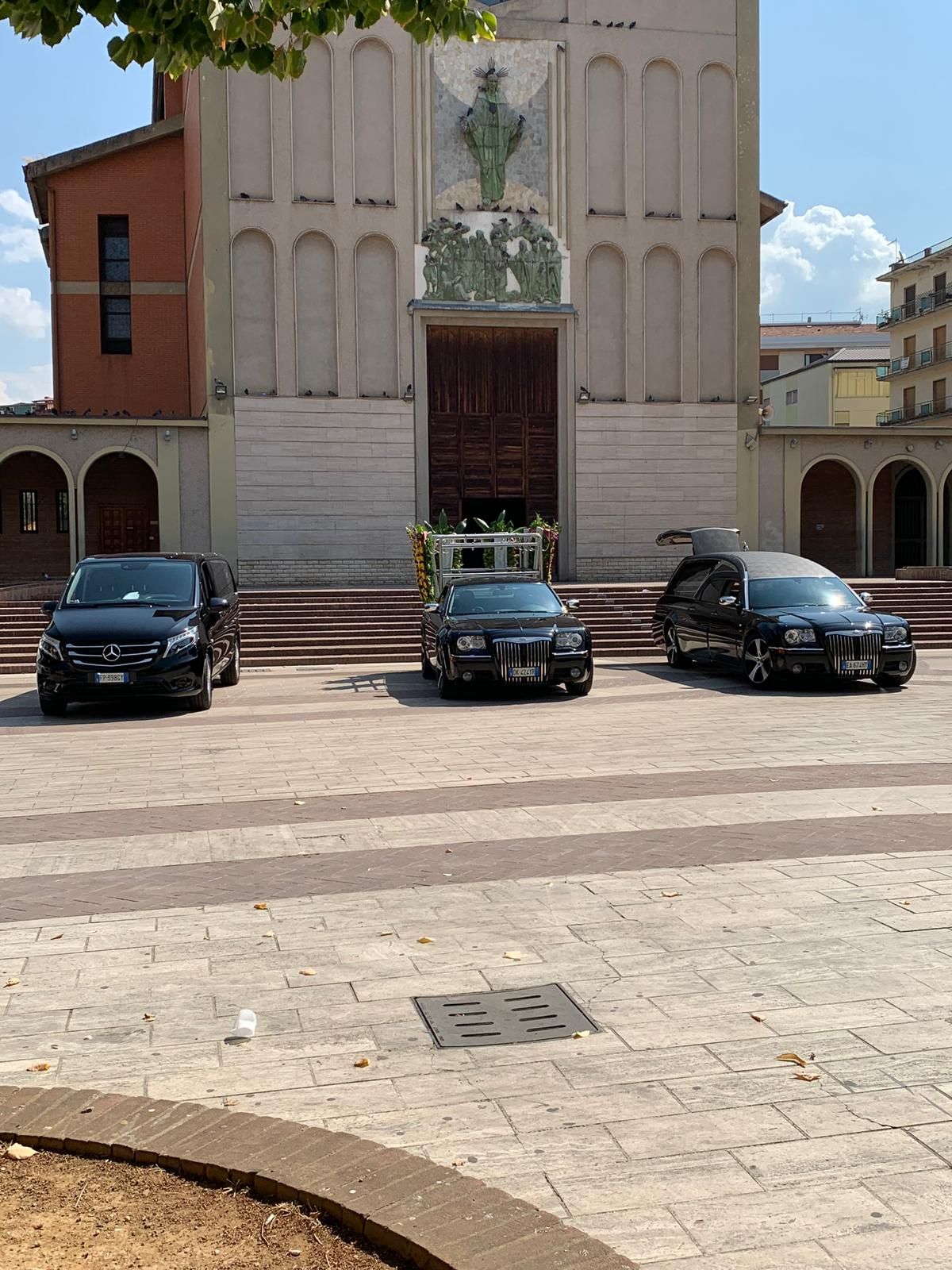 Tre auto sono parcheggiate davanti a una chiesa.