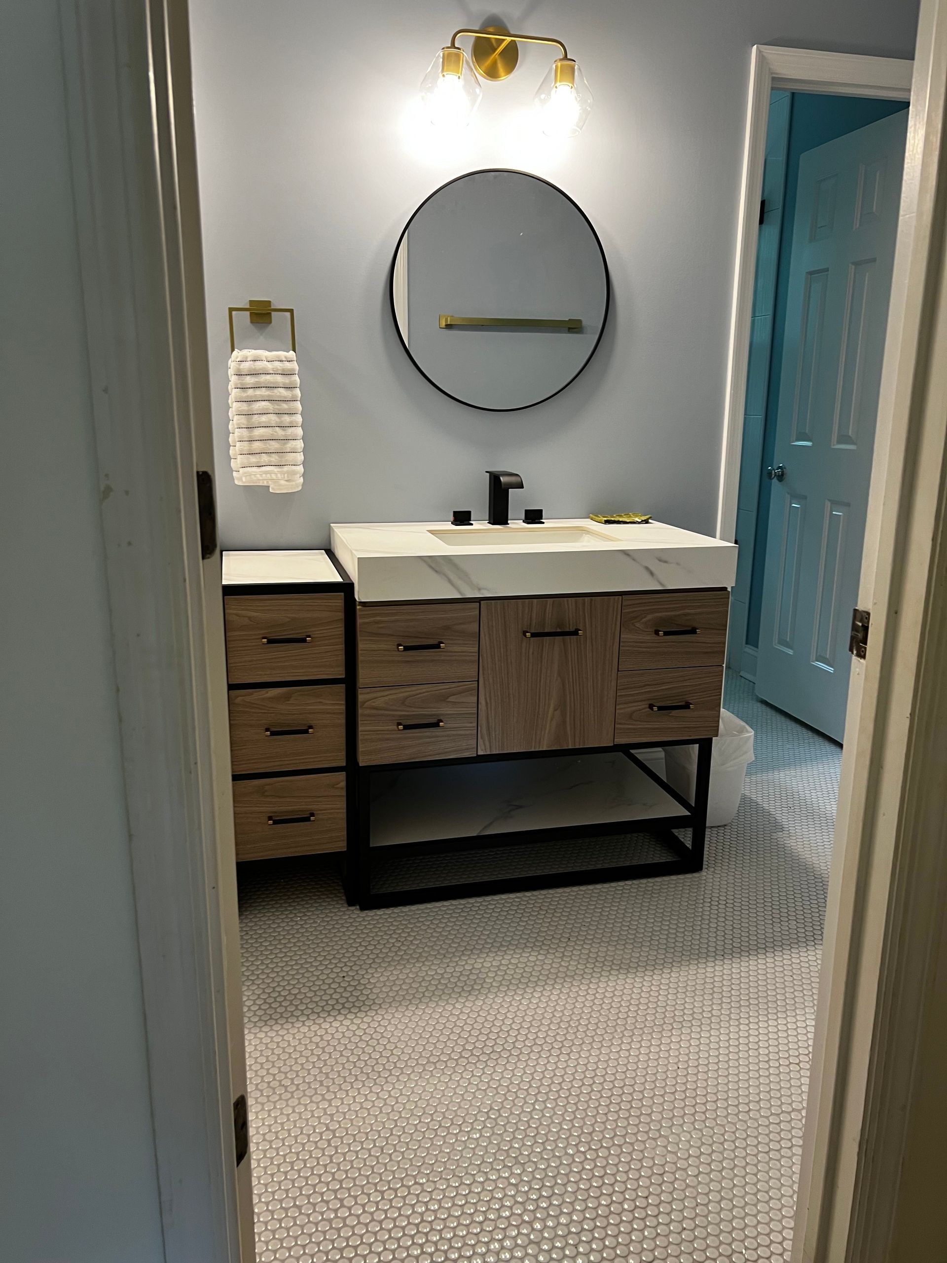 A bathroom with a sink , mirror and drawers.