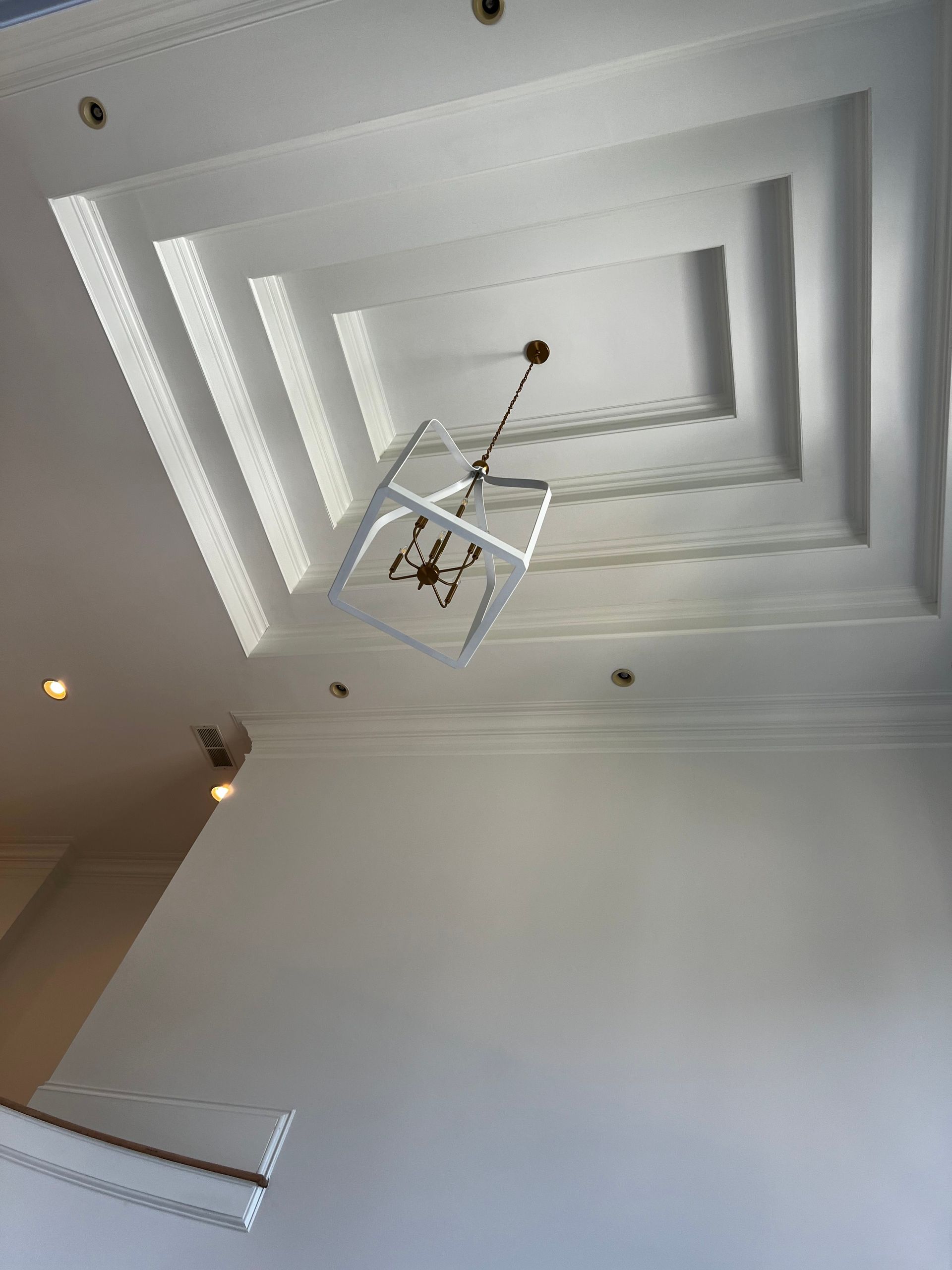 Looking up at the ceiling of a building with a chandelier hanging from it.
