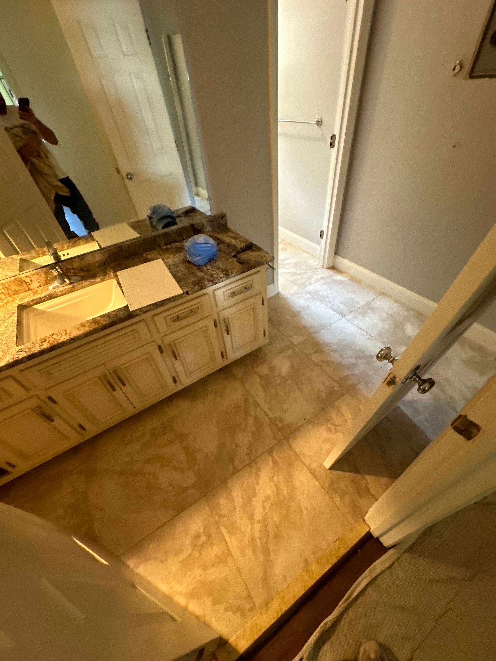 A bathroom with a sink , mirror and tile floor