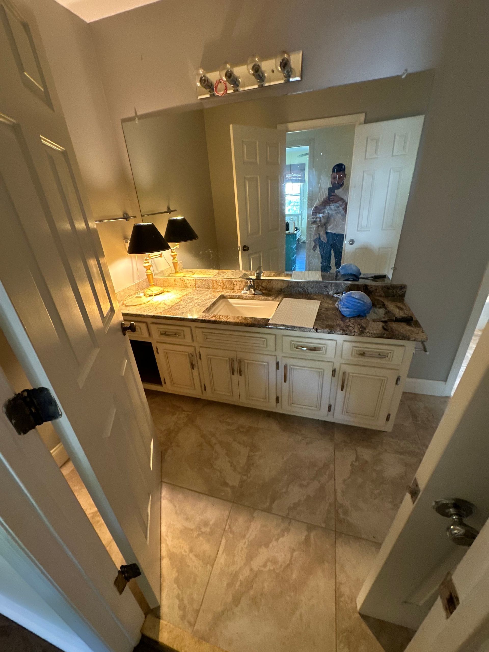 A bathroom with a large mirror and a sink.