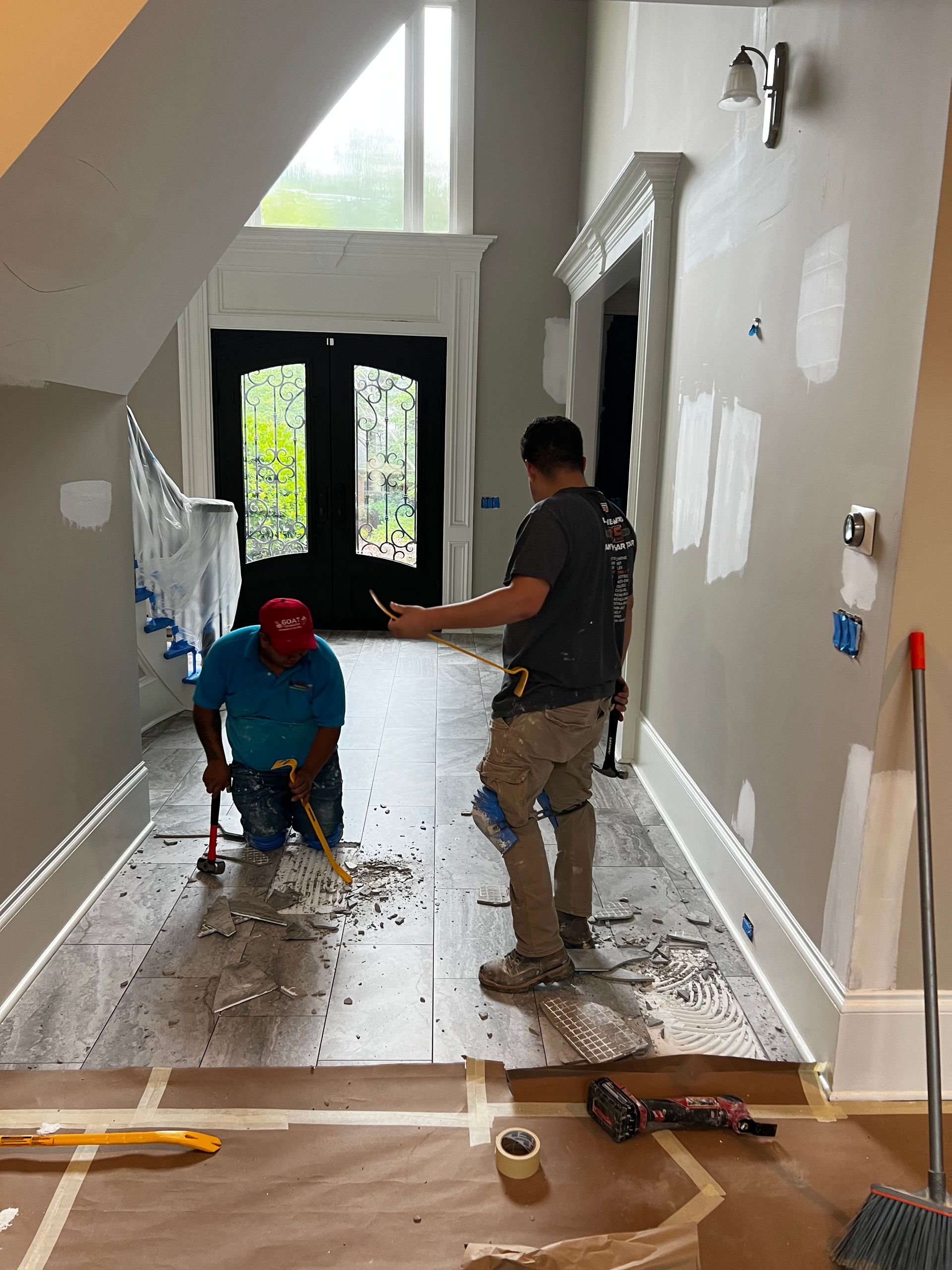 Two men are painting a hallway in a house.