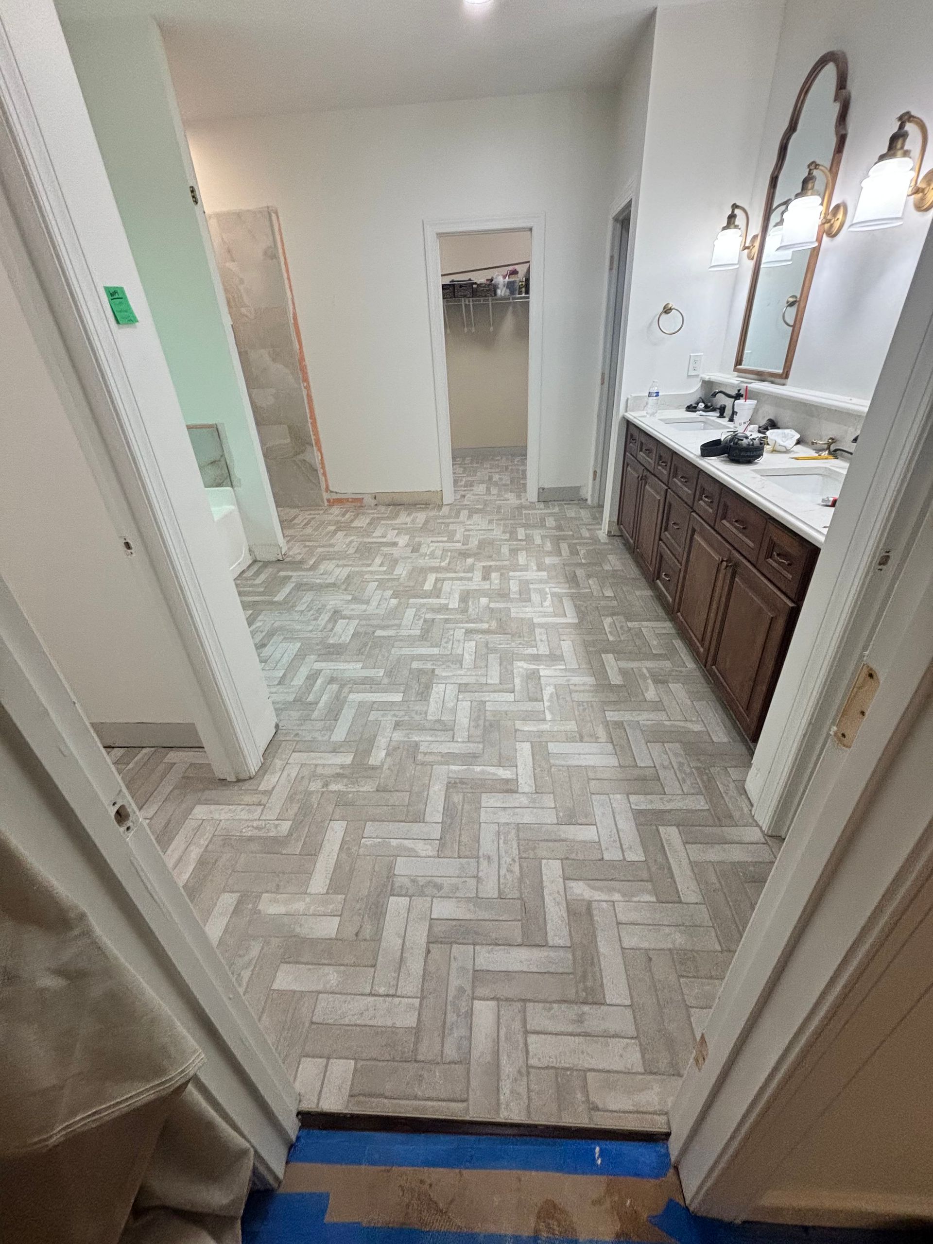 A bathroom with a herringbone floor and two sinks.