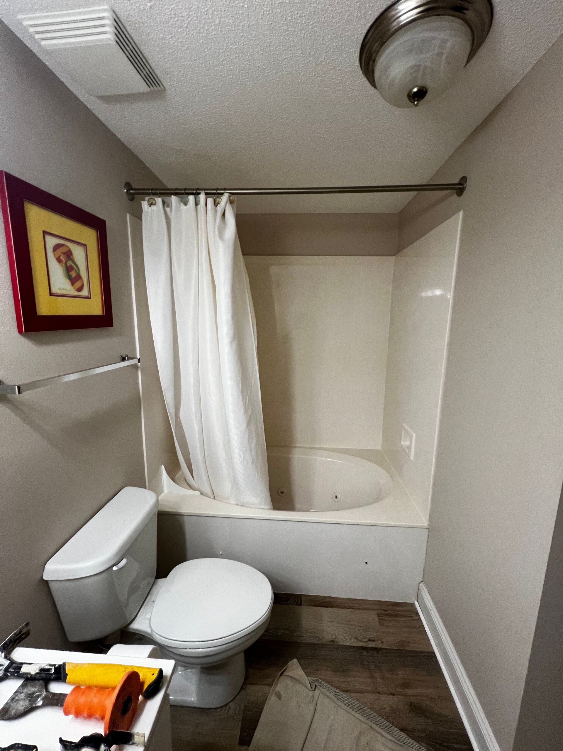 A bathroom with a toilet a tub and a shower curtain