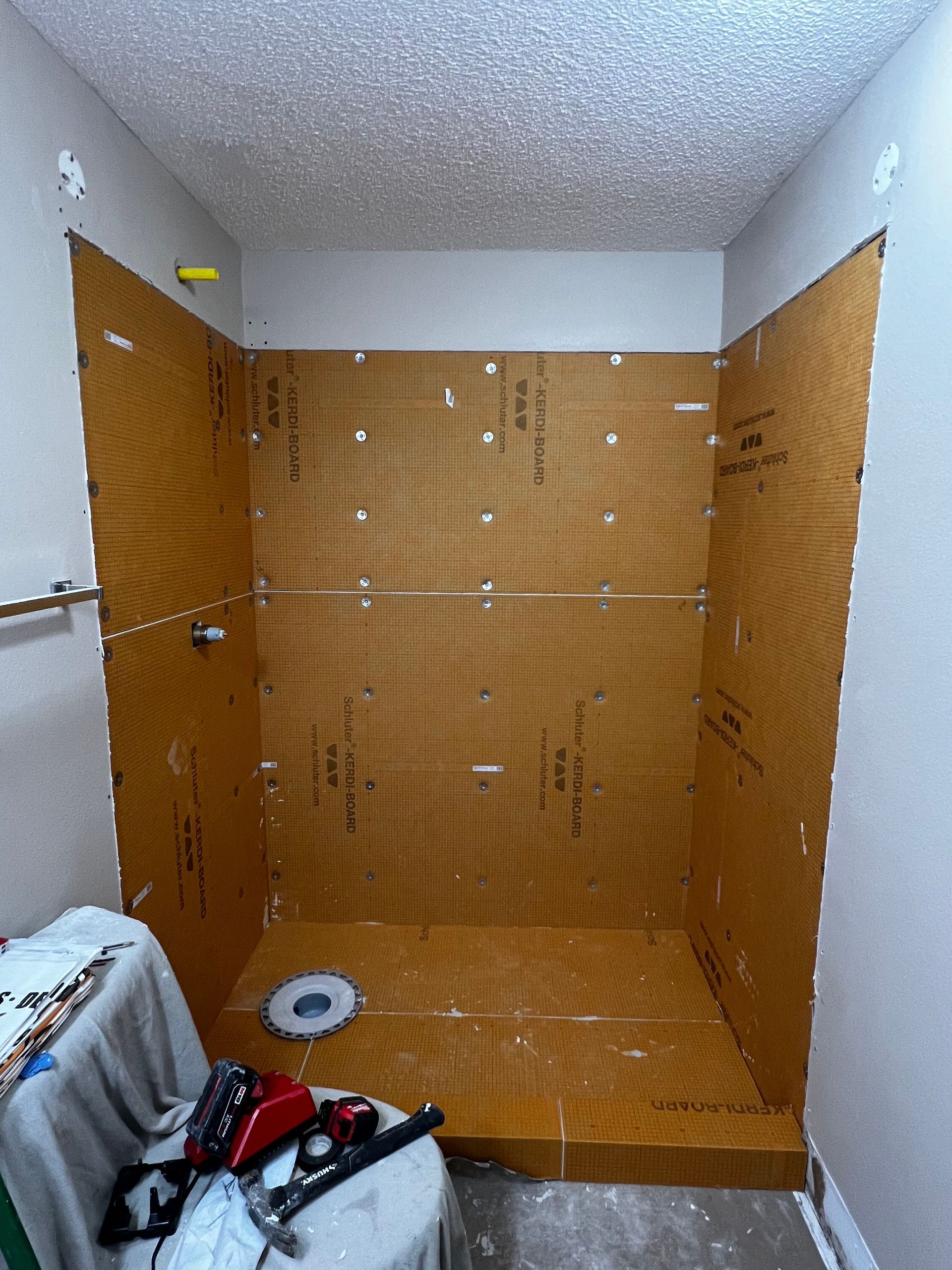 A bathroom with a toilet and a shower being built.