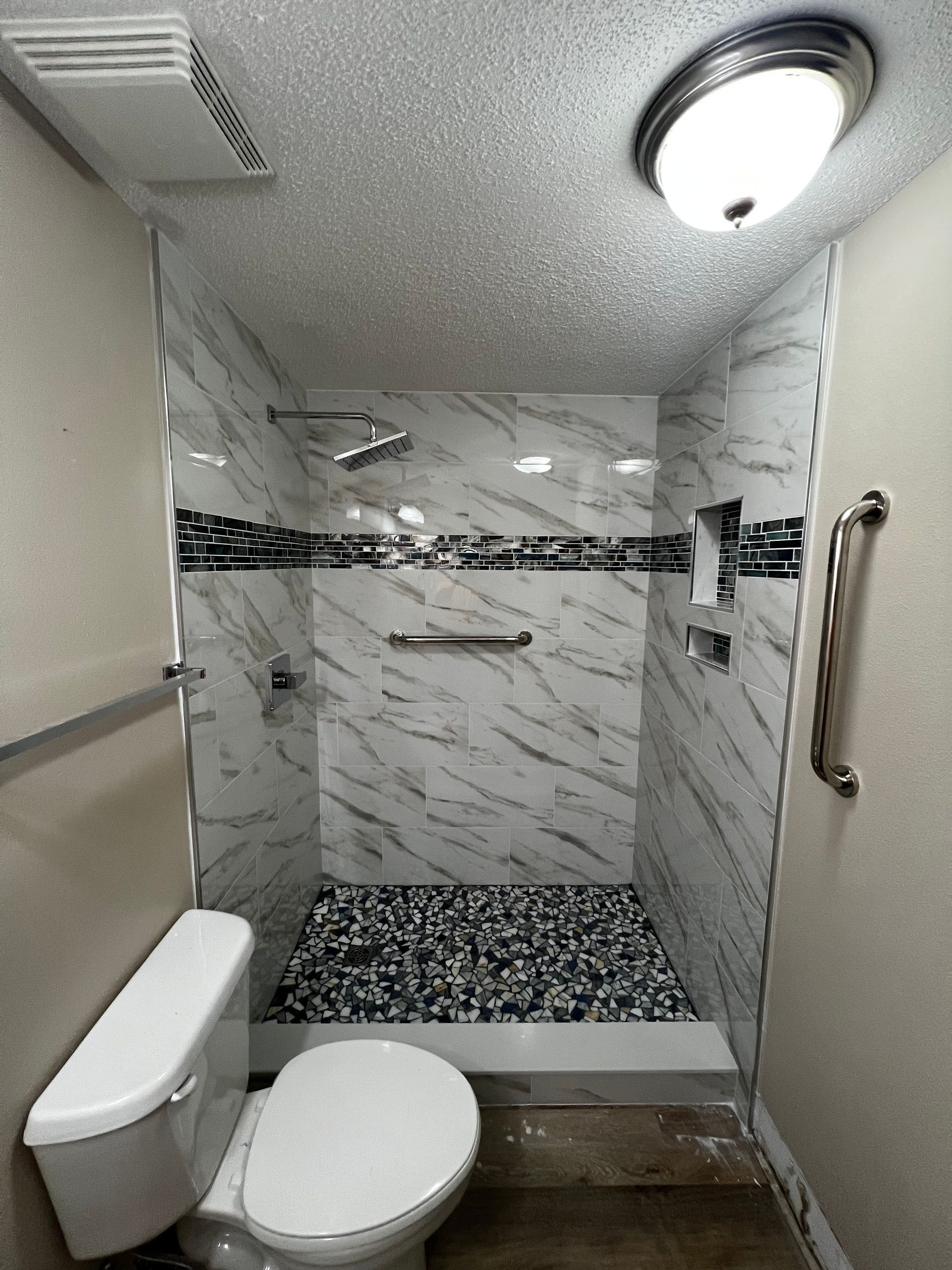 A bathroom with a toilet and a walk in shower