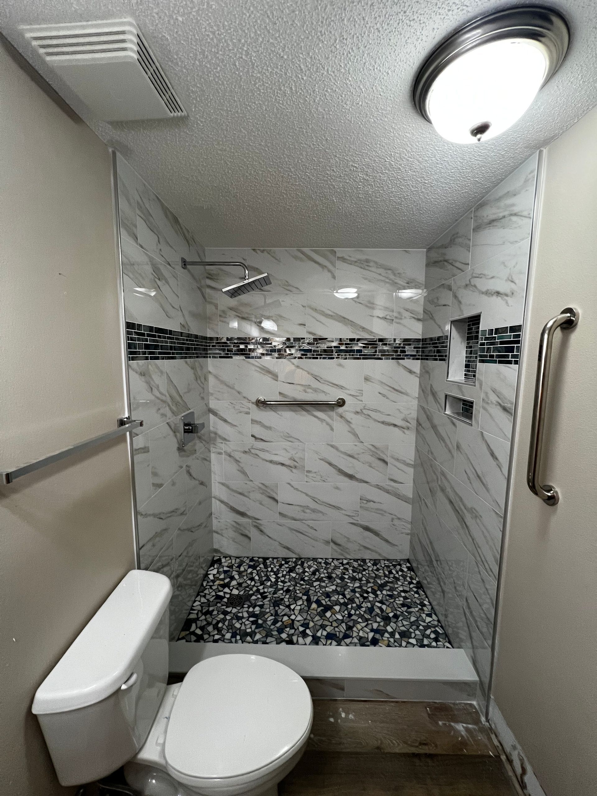 A bathroom with a toilet and a walk in shower