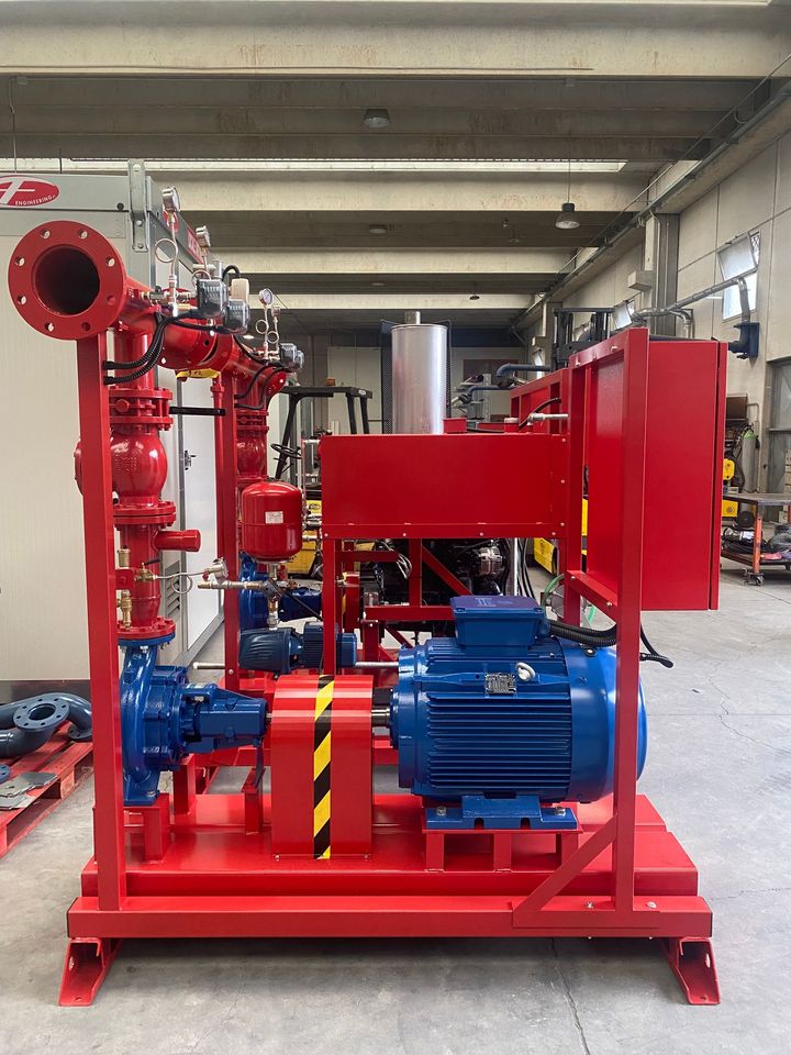 Macchinario industriale rosso e blu su un pallet in un magazzino o in un'officina.
