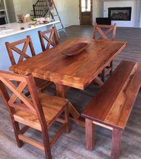 A Wooden Table With Chairs And A Bench In A Living Room