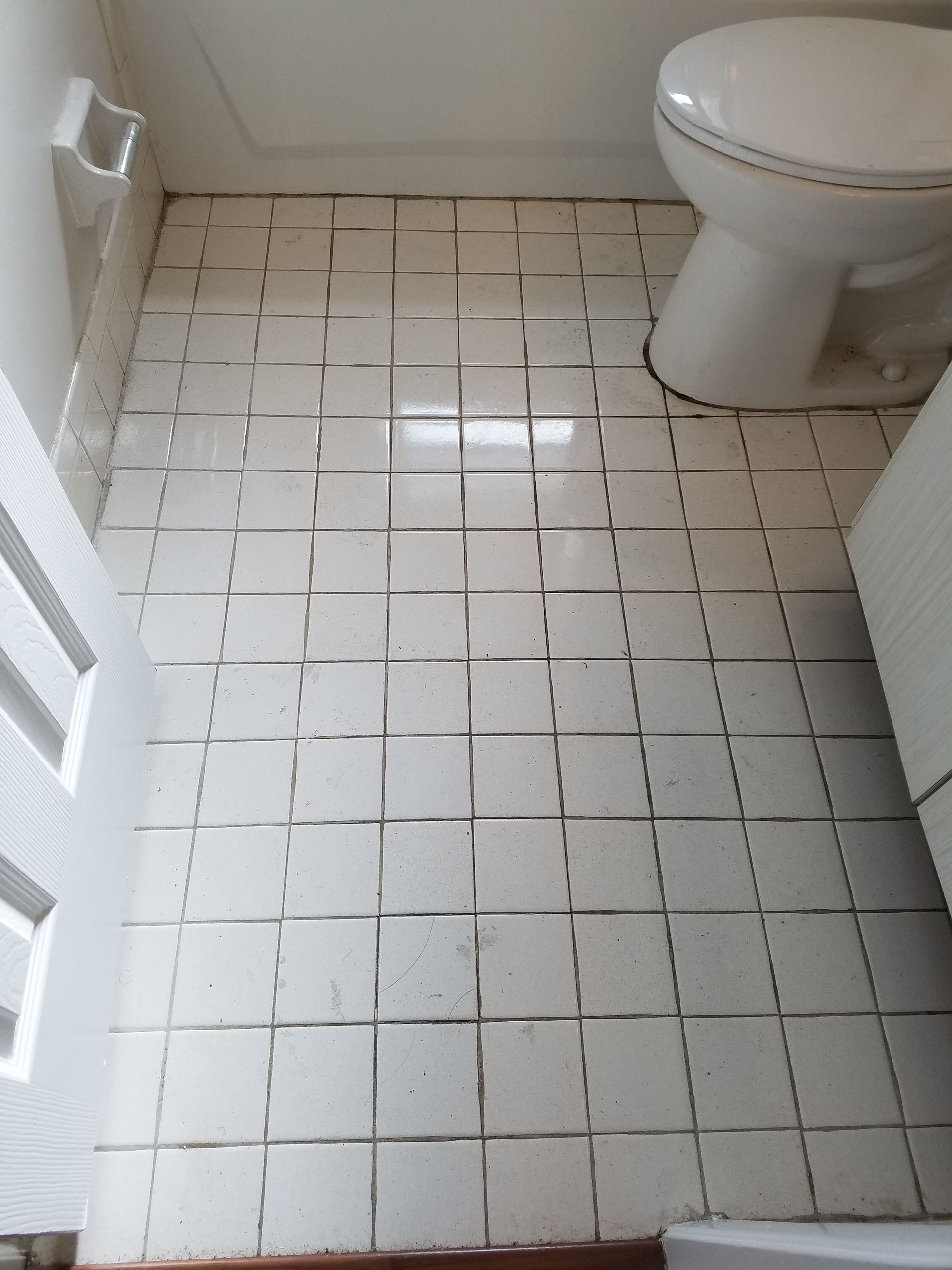 A bathroom with a toilet and a tiled floor