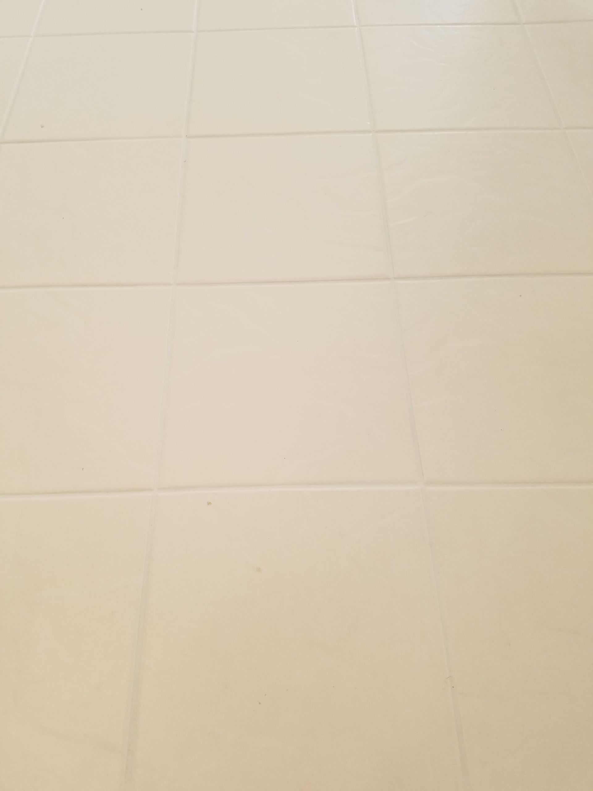A close up of a white tile floor.