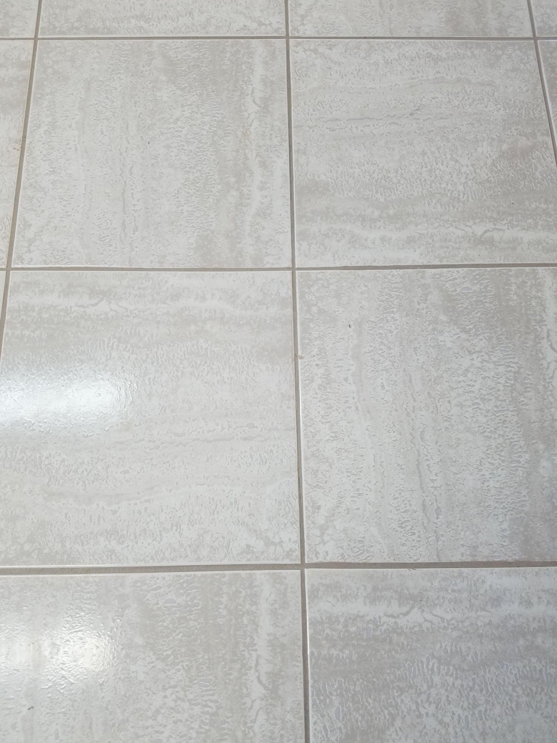 A close up of a tiled floor with a white grout.