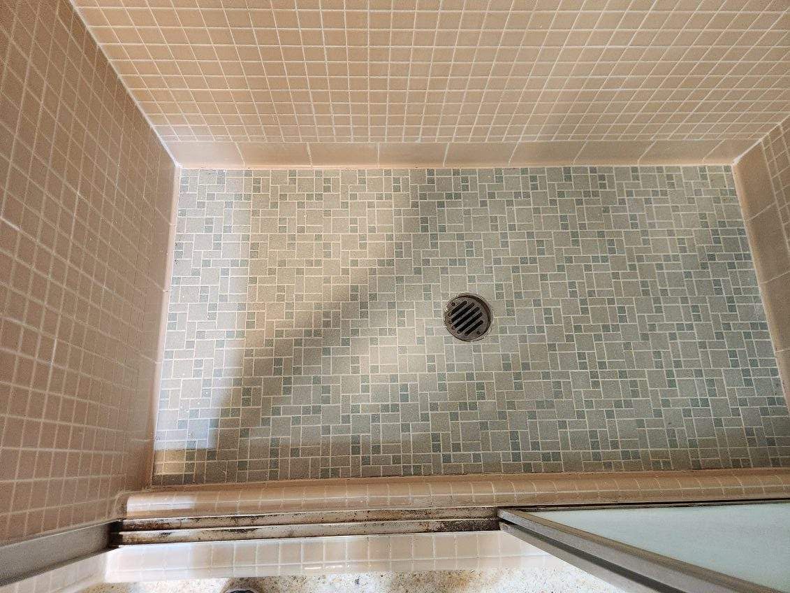 A shower stall with a drain on the floor