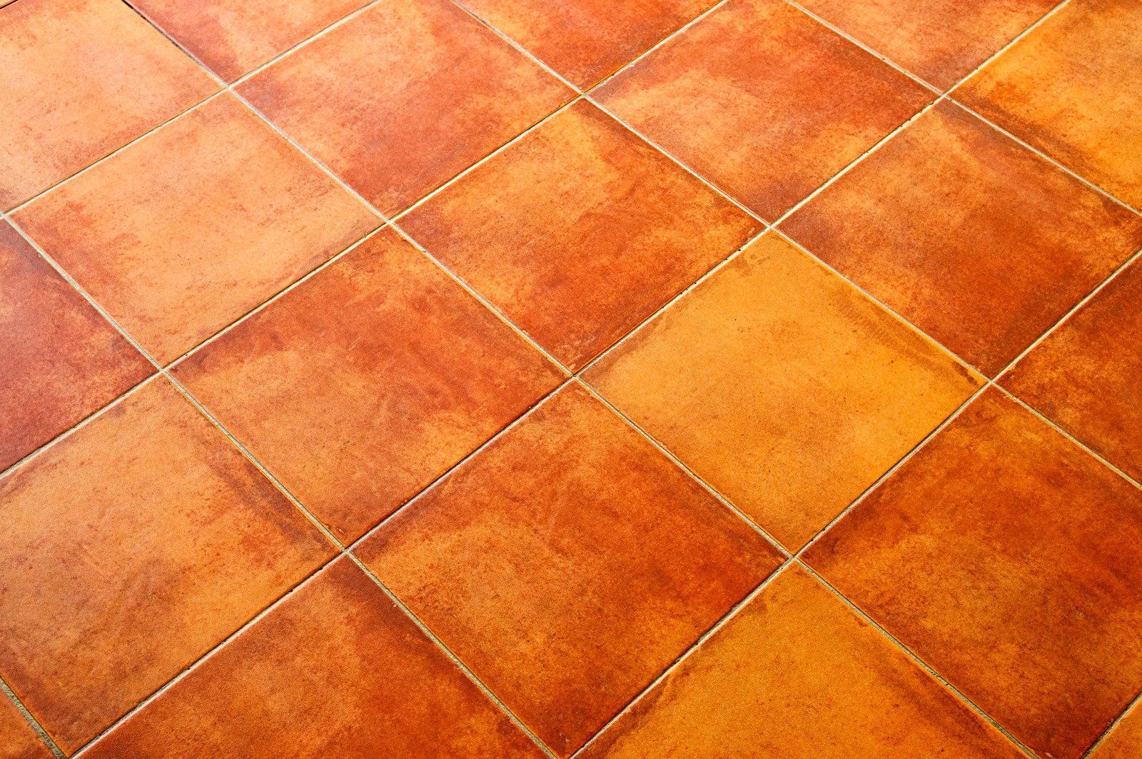 A close up of a tiled floor with a checkered pattern.