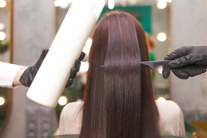 Hairdresser demonstrates the result of keratin hair straightening