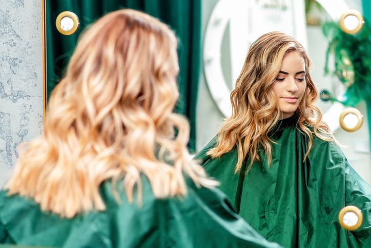 Young woman in salon with reflection in mirror