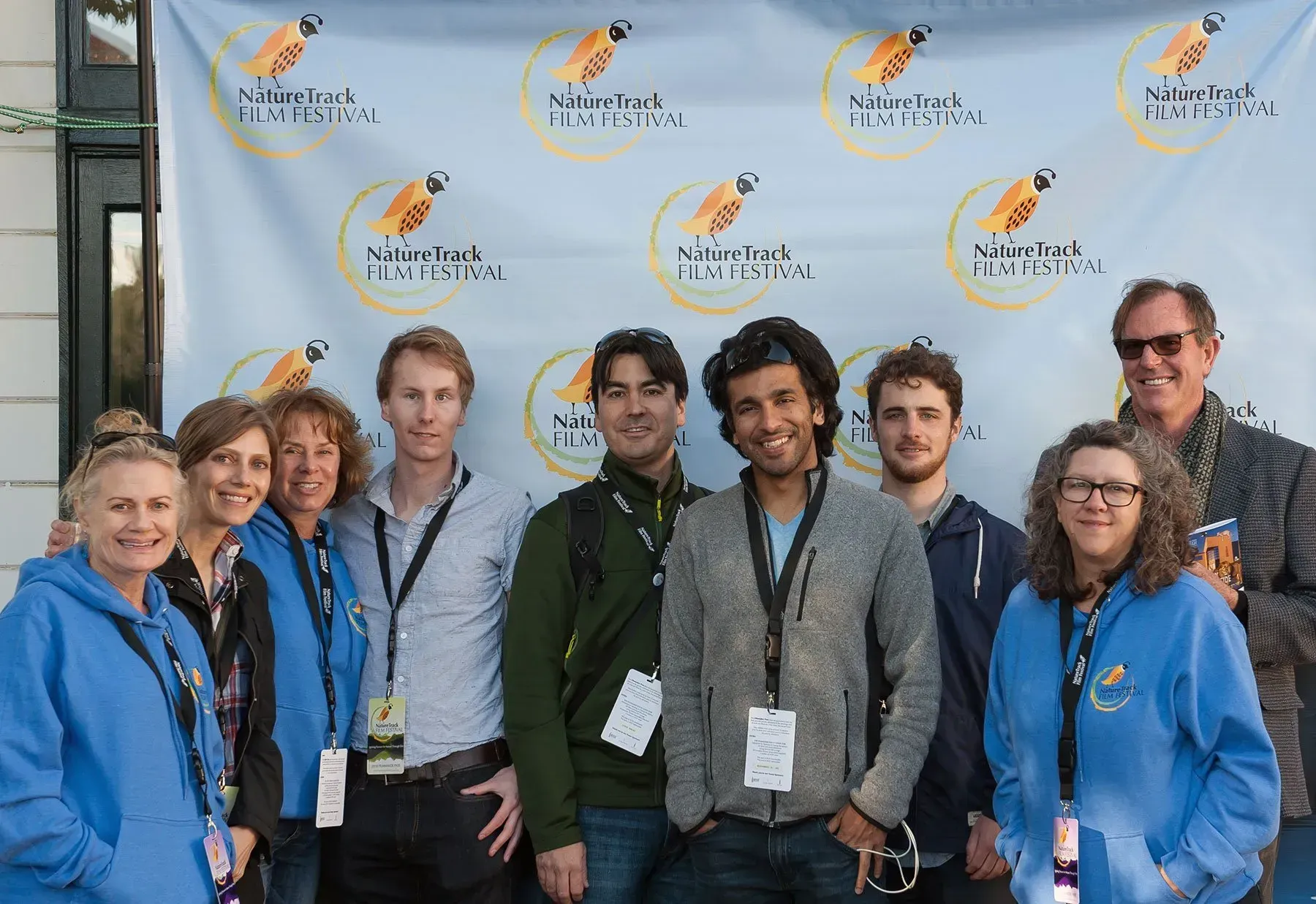 A group of people are posing for a picture in front of a banner with a carrot on it