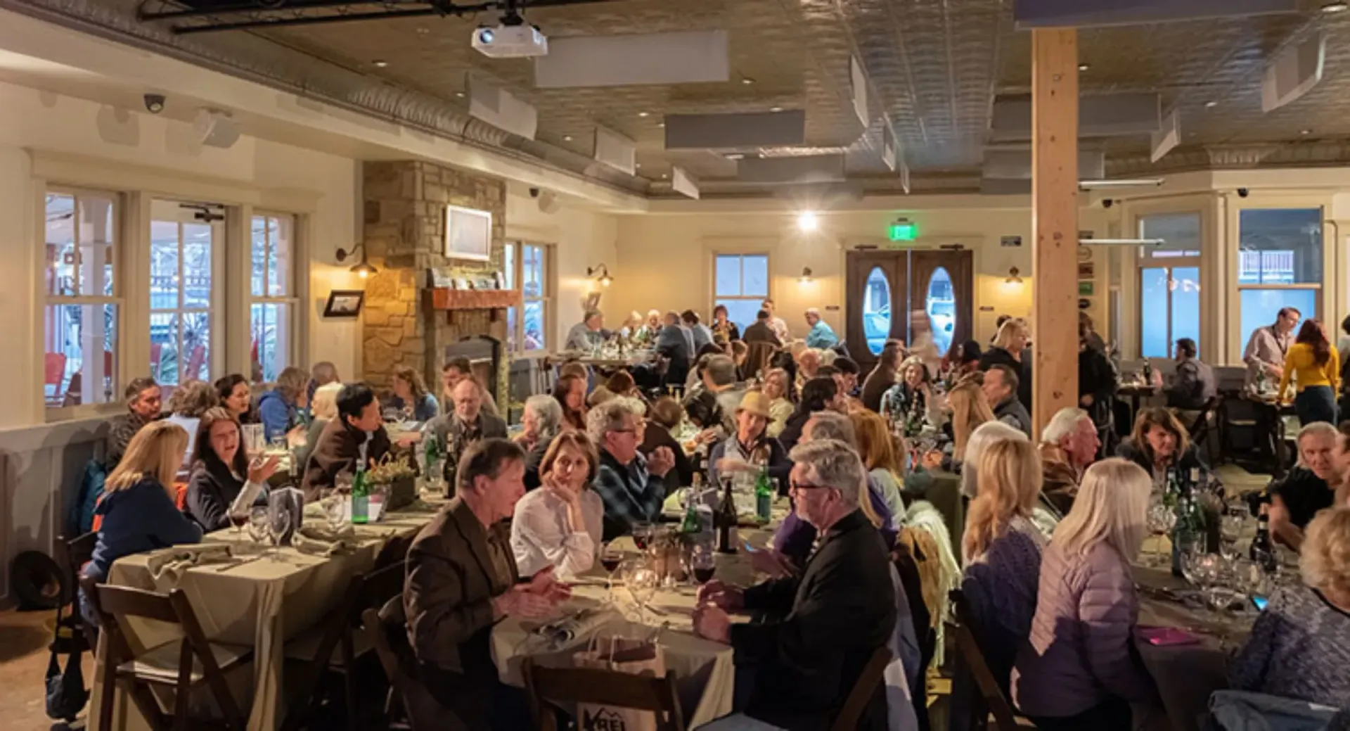 A large group of people are sitting at tables in a restaurant.