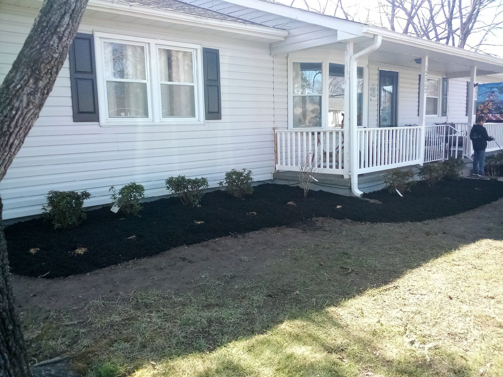 A white house with a porch and black shutters