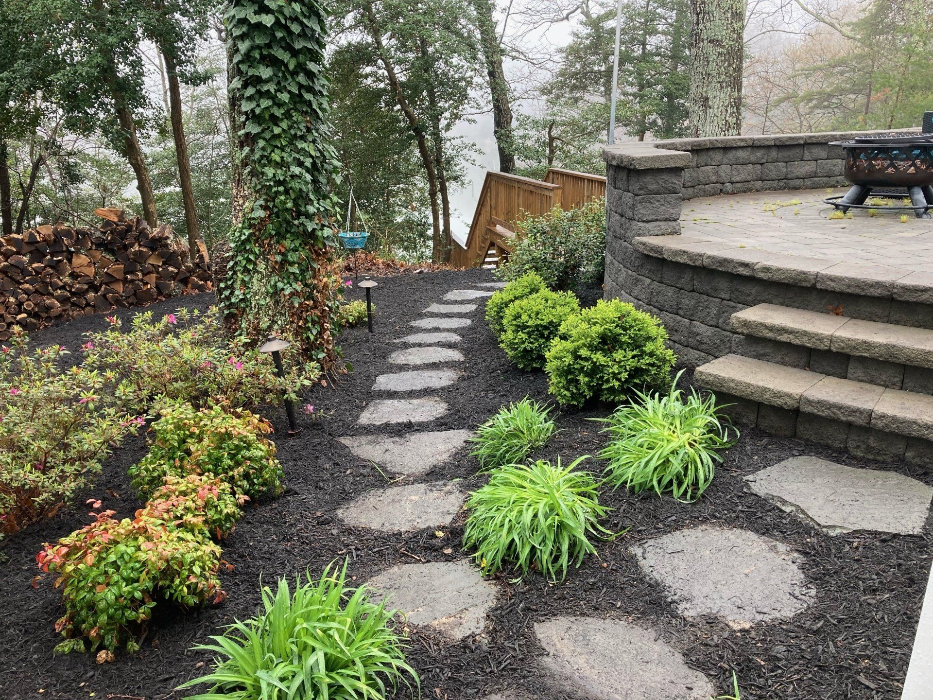 A stone walkway leading to a staircase in a garden.