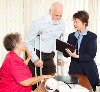 Injured man with crutches with wife meeting lawyer — Personal injury lawyer in Uniontown, PA