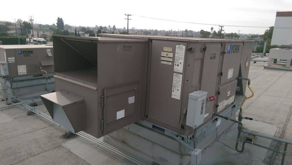 A large air conditioner is sitting on top of a roof.