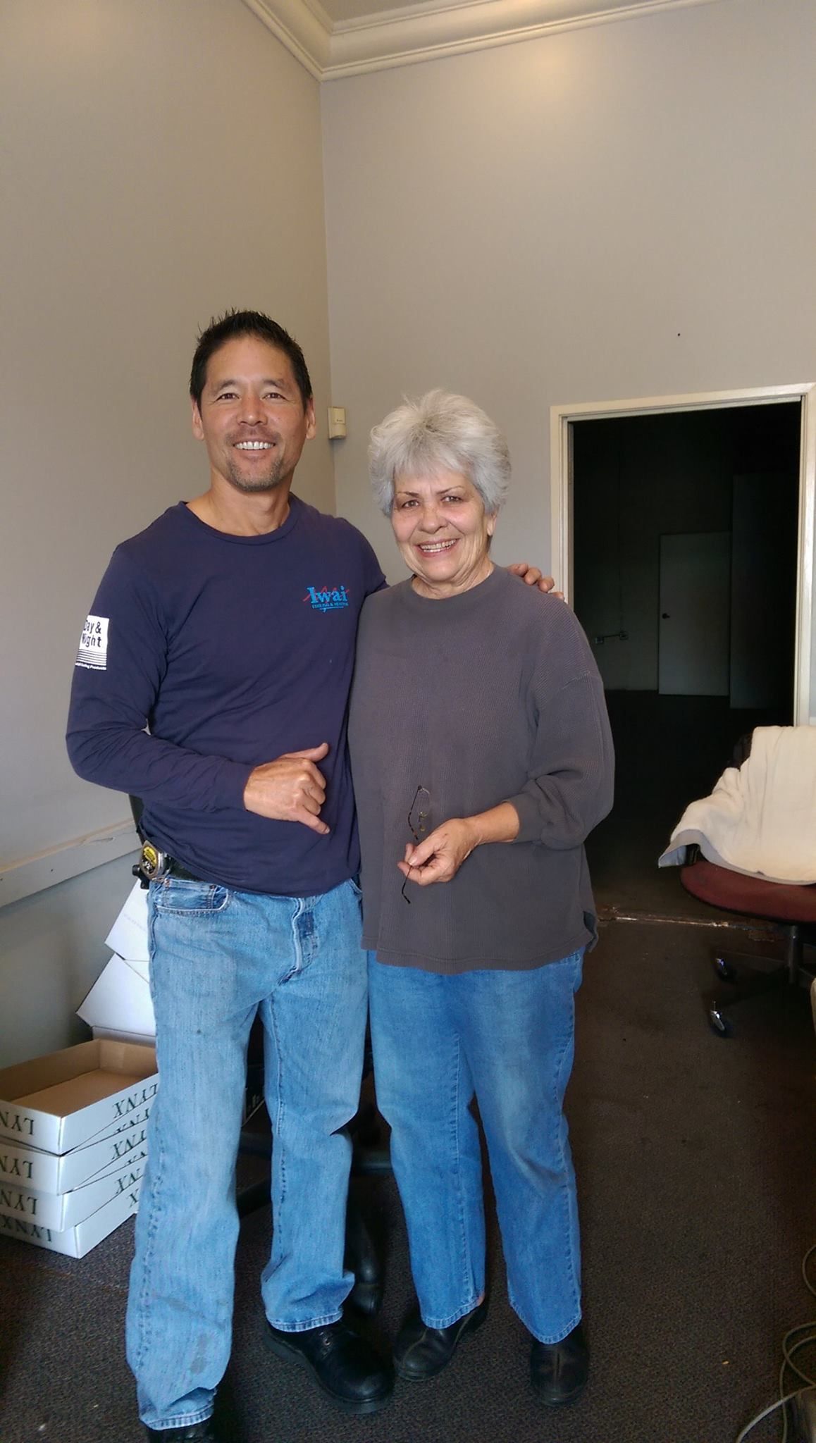 A man and a woman are posing for a picture in a room.