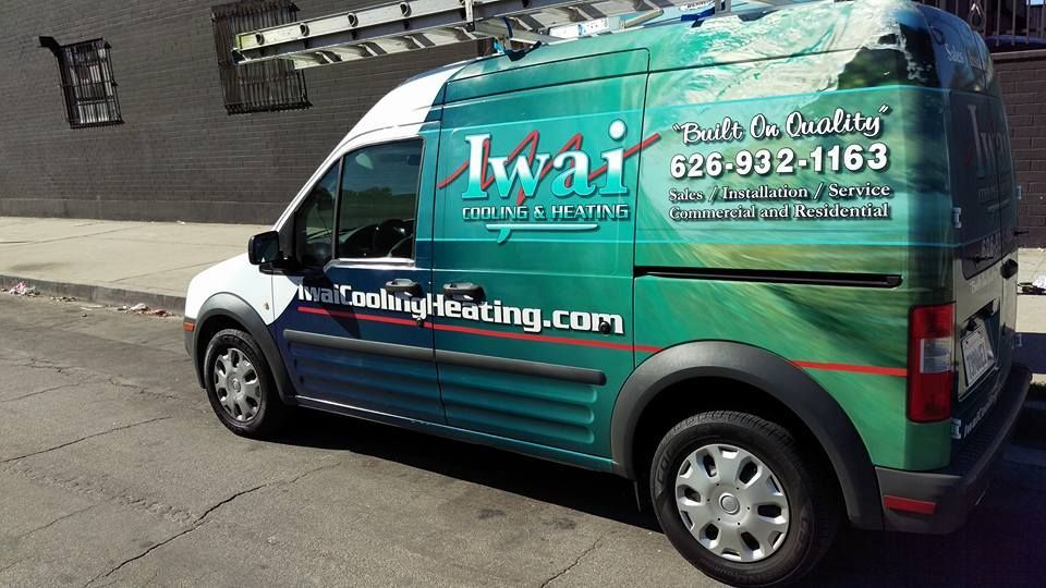 A green and white van with iwai written on the side