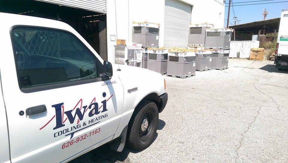 A white iwai truck is parked in front of a building