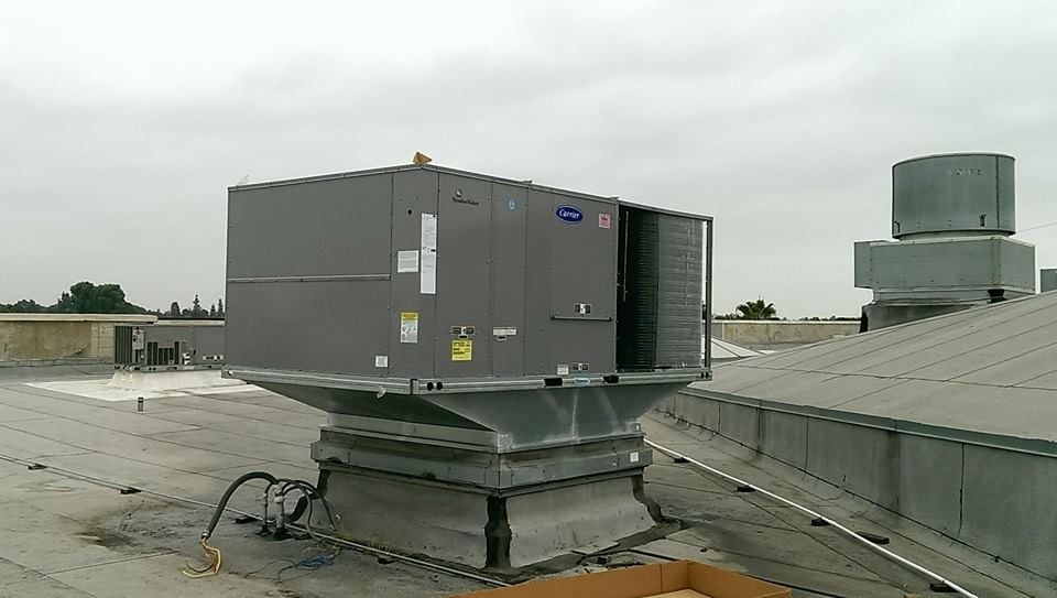 A large gray box is sitting on top of a roof.