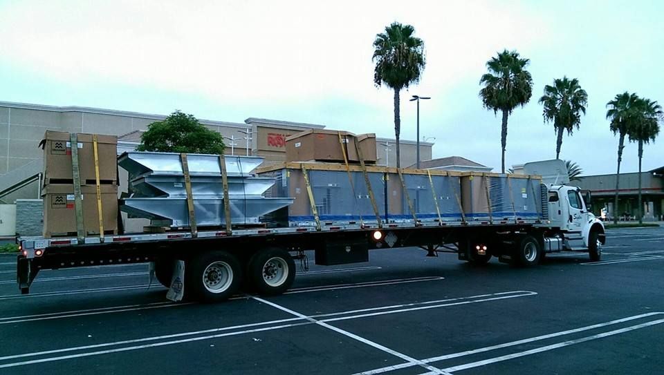 A semi truck with boxes on the back is parked in a parking lot